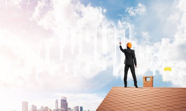 Erkek mimar mavi gökyüzüne modern şehrin siluetini çizer. Karışık ortam