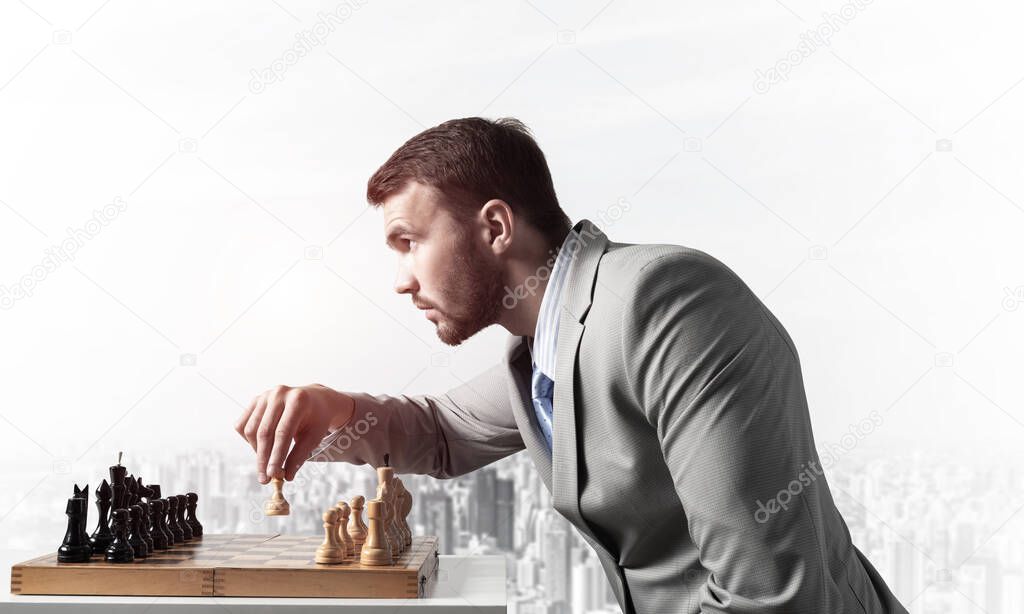 Concentrated businessman playing chess game