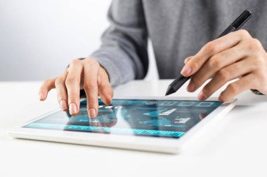 Kadın, hisse senedi ticareti için tablet bilgisayar kullanıyor. Kadın ellerinin tablet cihazının ekranına dokunuşunun yakın çekimi. Profesyonel online yatırım ve risk analizi. İş sürecinde mobil akıllı aygıt