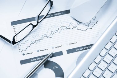 Klavye gözlüklü ve mali belgeleri masada olan iş yeri