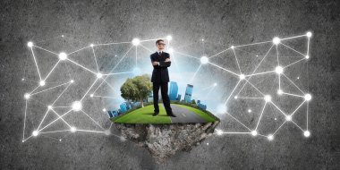 Uçan yeşil adada beton zeminde zarif bir işadamı.