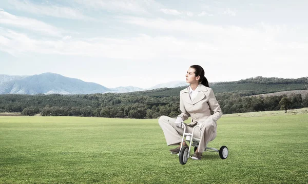 Όμορφη Νεαρή Γυναίκα Ιππεύει Παιδικό Ποδήλατο Πράσινο Γρασίδι Επιχειρηματίας Λευκό — Φωτογραφία Αρχείου