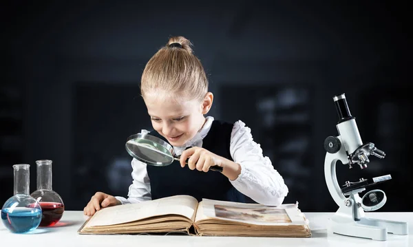 Mała Dziewczynka Siedząca Przy Biurku Lupą Otwartą Książką Badania Edukacja — Zdjęcie stockowe