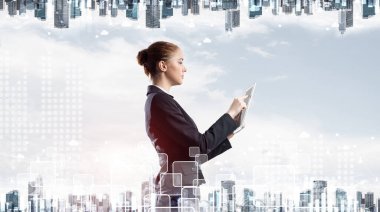 Modern şehir manzarası geçmişinde tablet bilgisayarı olan genç bir iş kadını. Takım elbiseli güzel bir kadınla çift pozlama konsepti. Hisse senedi ticareti ve emlak yatırımlarında dijital teknoloji