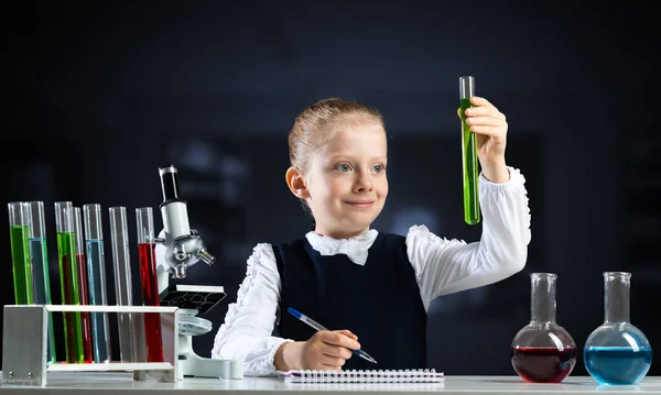 Pequeña científica examinando tubo de ensayo —  Fotos de Stock