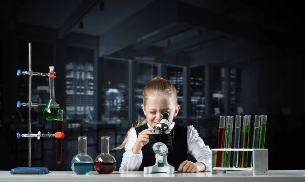 Cientista menina olhando através do microscópio — Fotografia de Stock