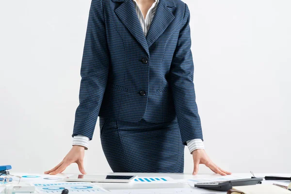 Businesswoman in suit standing near office desk — Stock Photo, Image