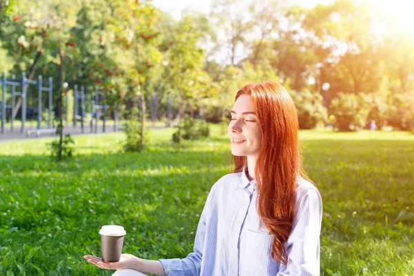 Mulher Ruiva Jovem Meditando Pose Lótus Com Xícara Café Grama — Fotografia de Stock