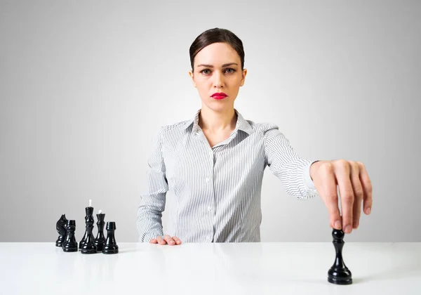 Masada satranç oynayan kendine güvenen bir iş kadını. — Stok fotoğraf