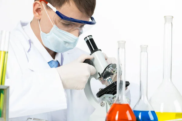 Scientist looking through microscope in laboratory — Stock Photo, Image