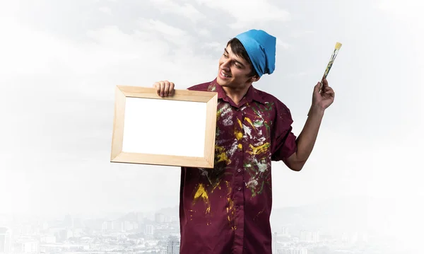 Young handsome painter artist holding paintbrush — Stock Photo, Image