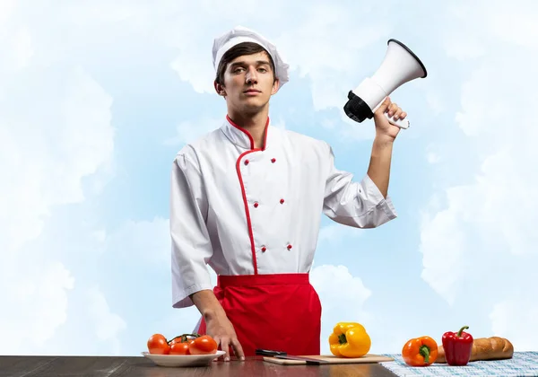 Νεαρός σεφ στέκεται με μεγάφωνο στο χέρι — Φωτογραφία Αρχείου