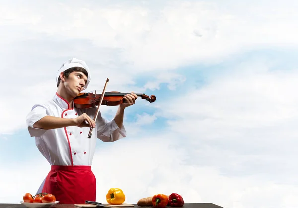 Νεαρό αρσενικό σεφ με βιολί στέκεται — Φωτογραφία Αρχείου