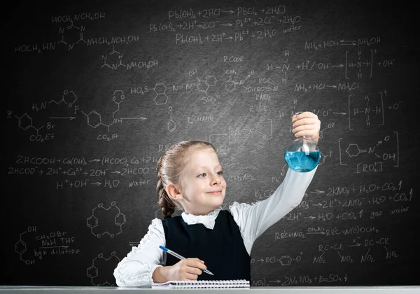 어린 소녀 과학자가 시험관을 검사하는 모습 — 스톡 사진