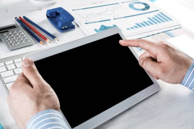 Tabletli bir işadamı, ofiste çalışıyor.