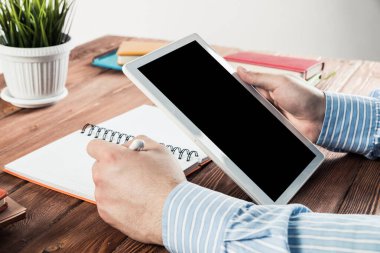 Tabletli bir işadamı, ofiste çalışıyor.