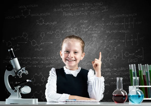 Pequena cientista sentada na mesa — Fotografia de Stock