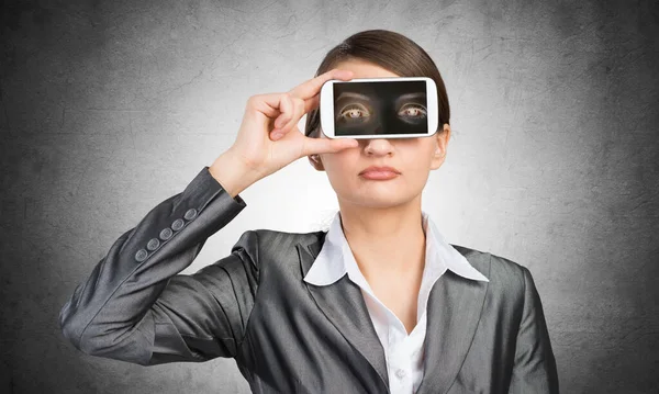Frau verdeckt ihre Augen mit Smartphone — Stockfoto