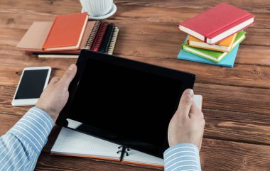 Tabletli bir işadamı, ofiste çalışıyor.