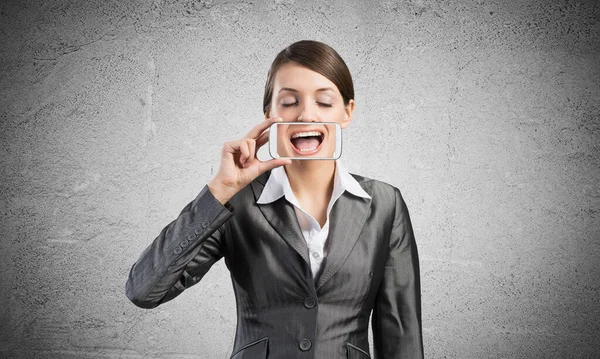 Žena zakrývající si ústa smartphonem — Stock fotografie