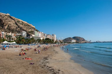 Alicante plajı boyunca insanların yaz güneşinin tadını çıkardığı panoramik manzara