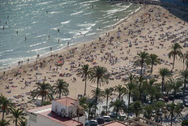 İspanya 'nın başkenti Costa Blanca' da sonbahar güneşinin tadını çıkaran çıngıraklı yıIdız desenli Alicante sahili üzerindeki hava veya insansız hava aracı manzarası