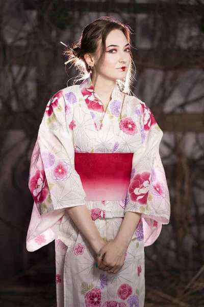 优雅的女孩在经典的传统礼服日本和服白色和粉红色独自站在黑暗背景在演播室 — 图库照片