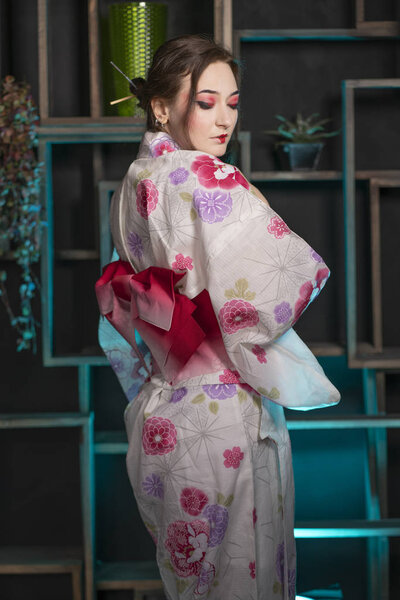 beautiful young woman standing at night in her room and posing in Japanese kimono alone