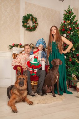 mutlu sevimli festively anne kostümleri ailesinde giyinmiş, baba ve iki kızı birbirlerine hediyeler vermek ve Noel sahiptir