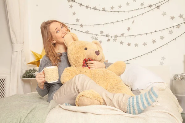 Menina Bonito Sentado Cama Roupas Confortáveis Malha Abraçando Grande Urso — Fotografia de Stock