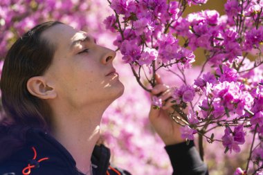 pembe çiçekli ormangülü ağacının bahçede Romantik adam yürüyor
