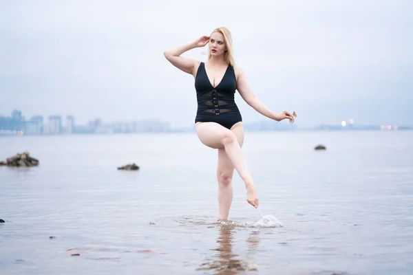 美しい欧州プラス サイズ女の子一人でビーチで黒い水着でポーズ — ストック写真
