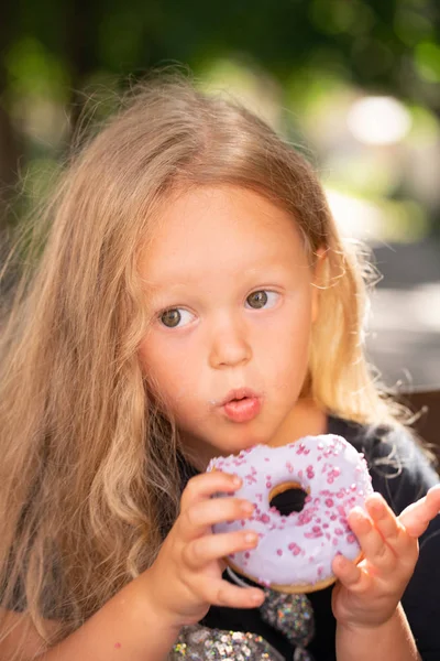 Mooie Schattig Klein Meisje Zittend Een Stoel Een Paarse Donut — Stockfoto