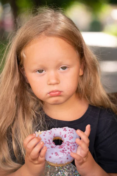 Mooie Schattig Klein Meisje Zittend Een Stoel Een Paarse Donut — Stockfoto