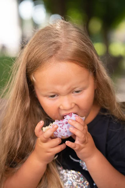 Mooie Schattig Klein Meisje Zittend Een Stoel Een Paarse Donut — Stockfoto