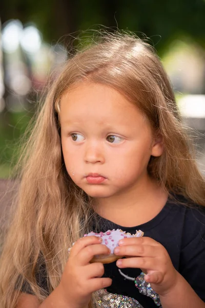 Vacker Söt Liten Flicka Sitter Stol Och Äta Lila Donut — Stockfoto