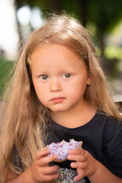 Mooie Schattig Klein Meisje Zittend Een Stoel Een Paarse Donut — Stockfoto