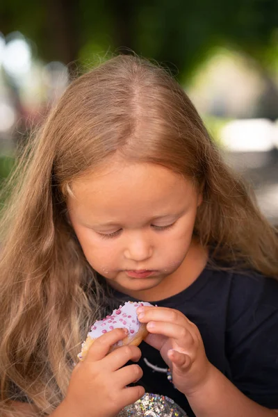 Mooie Schattig Klein Meisje Zittend Een Stoel Een Paarse Donut — Stockfoto