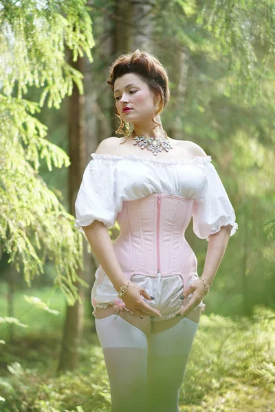 Beautiful young chubby girl posing in medieval retro corset and white vinta...
