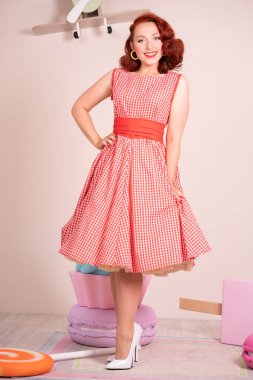 Mutlu kız retro kırmızı bir elbise ve beyaz topuklu poz gülümseyen güzel kızıl saçlı pinup