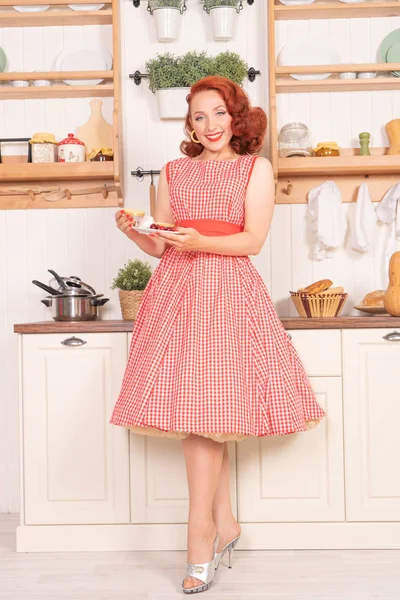 mutlu kız mutfakta yalnız bir retro kırmızı elbiseli poz gülümseyen güzel kızıl saçlı pinup