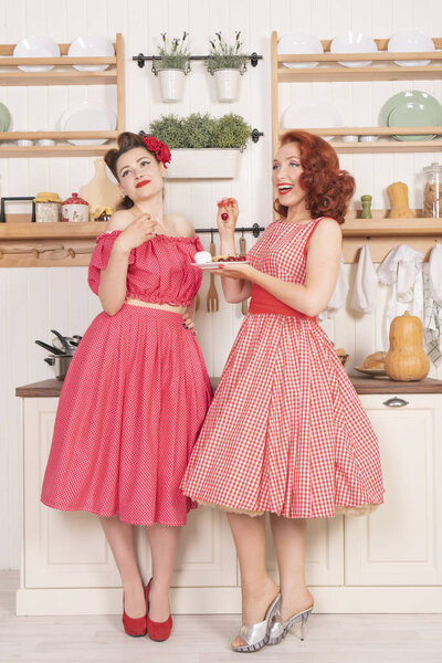 Pretty cute joyful ladies wearing vintage clothes and having fun in their white kitchen