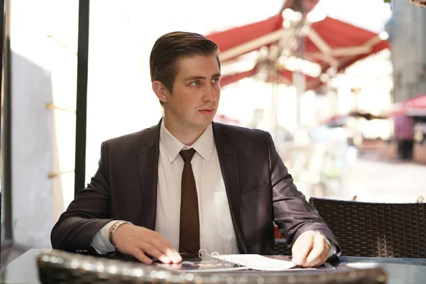 Young Businessman Came Lunch Street Cafe Sits Table Looks Menu — Stock Photo, Image