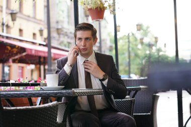 iş takım elbiseli bir genç adam dokunur ve kravatını düzeltiyor