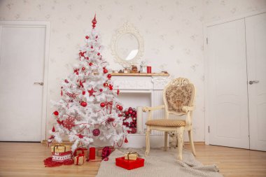 güzel beyaz Noel köknar ağacı şömine ve bej sandalye oda dekore edilmiş ve kimse ile katta halı örme