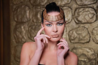 Tan poz esmer güzel. Mısır tarzı zengin lüks mücevher altın arka plan üzerinde kadınla.