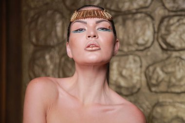 Tan poz esmer güzel. Mısır tarzı zengin lüks mücevher altın arka plan üzerinde kadınla.