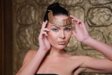 Tan poz esmer güzel. Mısır tarzı zengin lüks mücevher altın arka plan üzerinde kadınla.