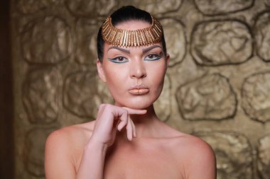 Tan poz esmer güzel. Mısır tarzı zengin lüks mücevher altın arka plan üzerinde kadınla.