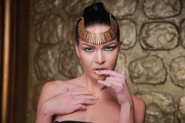 Tan poz esmer güzel. Mısır tarzı zengin lüks mücevher altın arka plan üzerinde kadınla.